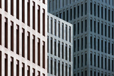 High multistory business buildings with rows of symmetric geometric windows located in downtown of megalopolis - ADSF49869