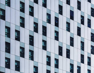 High multistory business buildings with rows of symmetric geometric windows located in downtown of megalopolis - ADSF49874