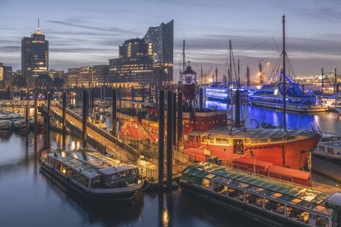 Deutschland, Hamburg, Boote im Hafen in der Abenddämmerung mit Elbphilharmonie im Hintergrund - KEBF02800