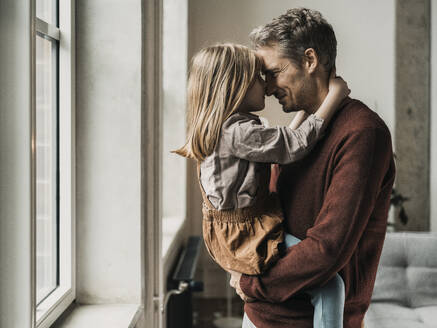 Father and daughter rubbing noses at home - MFF09525