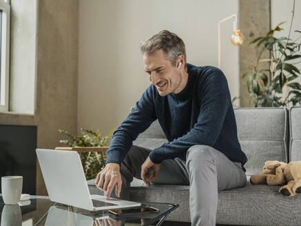 Happy freelancer working on laptop at home - MFF09533