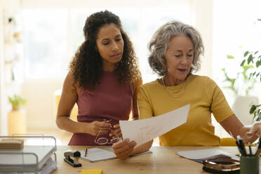 Geschäftsfrauen prüfen und diskutieren über Dokumente am Schreibtisch im Büro - EBSF04131