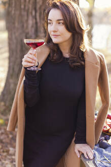 Schöne Frau hält Weinglas im Wald - ONAF00696