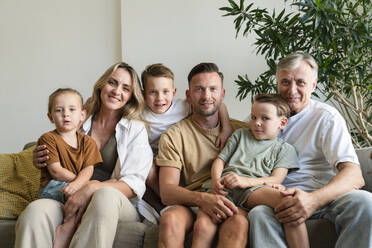 Lächelnder Großvater, Eltern und Kinder im heimischen Wohnzimmer - SVKF01708