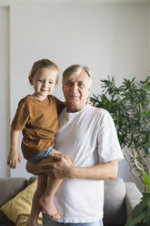 Großvater hält Enkel im heimischen Wohnzimmer - SVKF01728