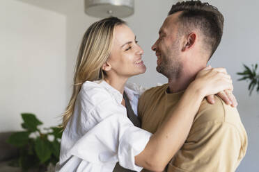 Happy man and woman hugging at home - SVKF01744