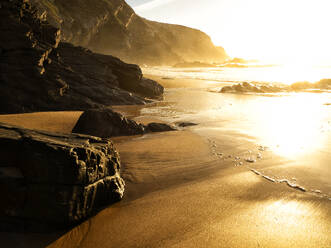 Portugal, Alentejo, Die untergehende Sonne beleuchtet den Strand von Cavaleiro - DSGF02444