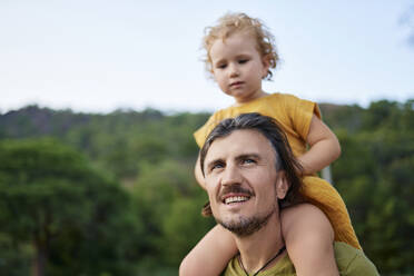 Thoughtful man carrying daughter on shoulders - ANNF00718