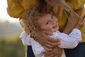 Glückliches Mädchen umarmt Mutter im Park - ANNF00752