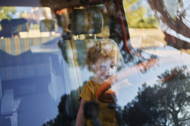 Mädchen auf dem Fahrersitz eines Wohnwagens durch die Windschutzscheibe gesehen - ANNF00767