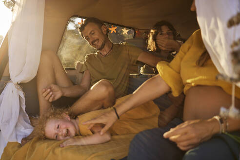 Lächelnde Familie verbringt ihre Freizeit gemeinsam im Wohnmobil im Urlaub - ANNF00793