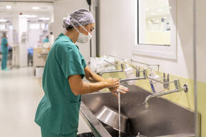 Nurse wearing mask washing hands in hospital - MMPF01022