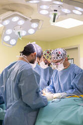 Surgeon and nurses doing surgery of patient in emergency room - MMPF01027
