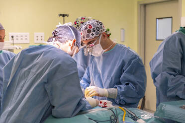 Surgeons performing surgery on patient in operating room - MMPF01035