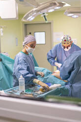 Surgeons performing surgery on patient in hospital - MMPF01037