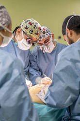 Chirurgen bei der Operation eines Patienten im Operationssaal eines Krankenhauses - MMPF01040