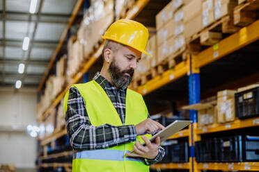 Portrait of a warehouse worker or a supervisor with digital tablet. - HPIF31148