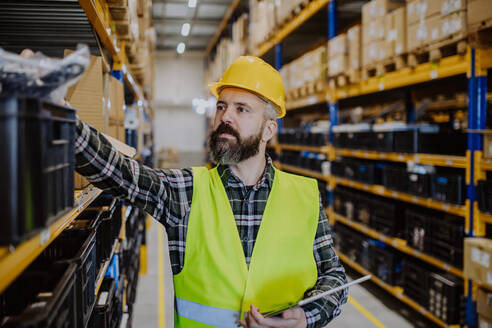 Warehouse worker checking up stuff in warehouse. - HPIF31151