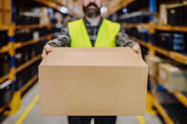 Close-up of warehouse worker stocking goods in warehouse. - HPIF31155
