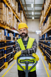 Male warehouse worker pushing the pallet truck. - HPIF31160