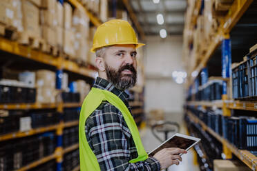 Portrait of a warehouse worker or a supervisor with digital tablet. - HPIF31163