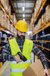 Warehouse worker stocking goods in warehouse. - HPIF31167