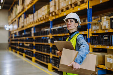 Warehouse female worker checking up stuff in warehouse. - HPIF31186