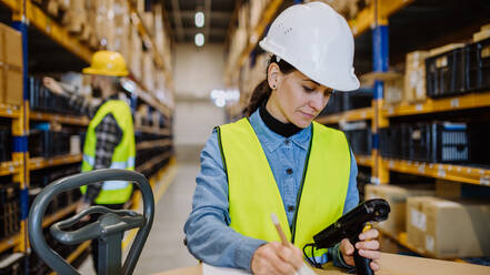 Warehouse workers checking stuff in a warehouse with digital system. - HPIF31191