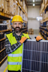 Portrait of warehouse worker with a solar panel. - HPIF31208