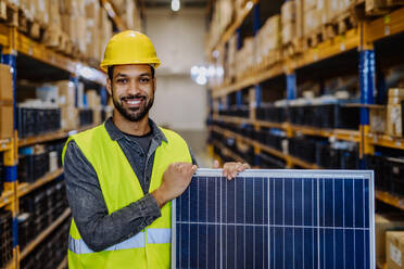 Portrait of warehouse worker with a solar panel. - HPIF31209