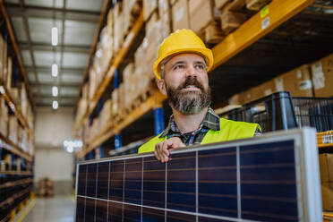 Portrait of warehouse worker with a solar panel. - HPIF31216