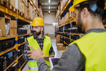 Warehouse workers checking stuff in warehouse with digital system in a tablet. - HPIF31222