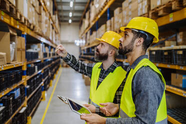 Warehouse workers checking stuff in warehouse with digital system in a tablet. - HPIF31225