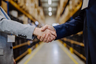 Close-up of managers shaking hands in a warehouse. - HPIF31239