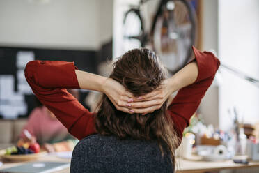 Rear view of young woman stretching in a work, having break. - HPIF31339