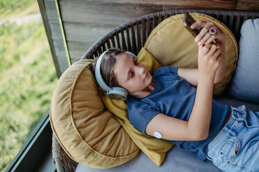 Diabetic girl watching social media content on smart phone.The CGM device makes the life of the schoolgirl. easier, helping manage his illness and focus on other activities. - HPIF31363