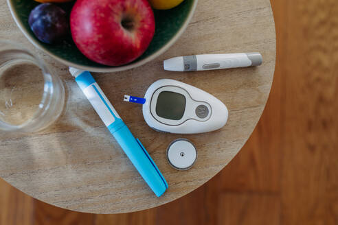 Nahaufnahme von Diabetes-Zubehör und -Geräten auf dem Tisch: Kontinuierlicher Glukosemonitor, Insulin-Pen, Blutzuckermessgerät. Banner mit Kopierbereich. - HPIF31375