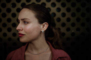 Profile portrait of a stunning woman with green eyes. Headshot of a woman standing in the darkness. - HPIF31429