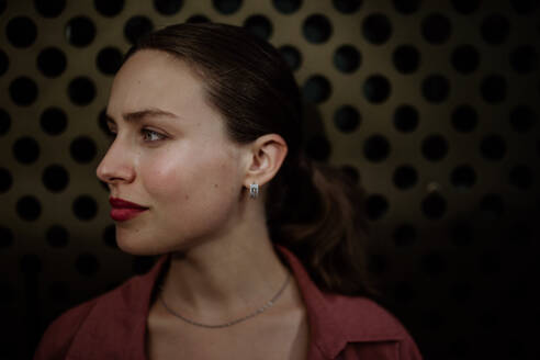 Profile portrait of a stunning woman with green eyes. Headshot of a woman standing in the darkness. - HPIF31429