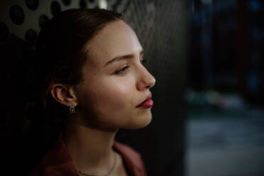 Profile portrait of a stunning woman with green eyes. Headshot of a woman standing in the darkness. - HPIF31430