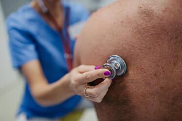 Female doctor listening to the bowel sounds of overweight patient using stethoscope. Obesity affecting middle-aged men's health. Concept of health risks of overwight and obesity. - HPIF31456