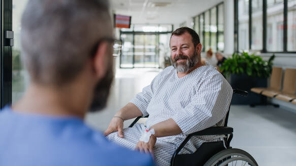 Nahaufnahme eines unterstützenden Arztes im Gespräch mit einem besorgten übergewichtigen Patienten im Rollstuhl. Krankheiten bei Männern mittleren Alters. Mitfühlender Arzt, der den gestressten Patienten unterstützt. Konzept der Gesundheitsrisiken von Fettleibigkeit. - HPIF31506