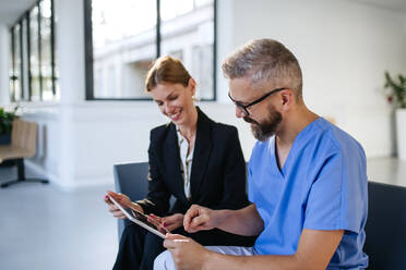 Pharmaceutical sales representative talking with doctor in medical building. Ambitious female sales representative presenting new medication, pills. Woman business leader. - HPIF31517