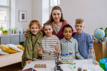 Porträt einer jungen Lehrerin mit ihren Schülern während des naturwissenschaftlichen Unterrichts. - HPIF31553