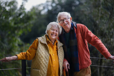 Happy senior couple at autumn walk near a lake, having break. - HPIF31634