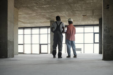 Engineer having discussion with construction worker at site - DSHF01341