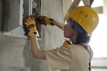 Electrician working on electric meter at construction site - DSHF01353