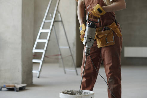 Bauarbeiter beim Mischen von Zement auf der Baustelle - DSHF01361