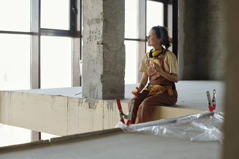 Smiling construction worker having lunch at site - DSHF01367