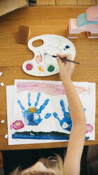Mädchen malt mit Aquarellfarben zu Hause - ASHF00025